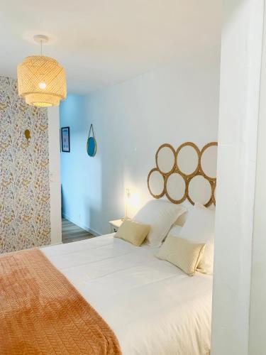 une chambre avec un grand lit avec des draps blancs dans l'établissement La maison des trois mâts, à Rochefort