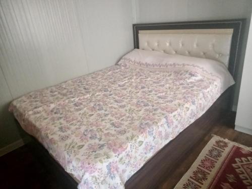 un piccolo letto in una stanza con un copriletto sopra di Karavan Kır Evi a Muğla