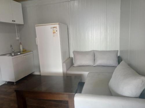 un soggiorno con divano e frigorifero di Karavan Kır Evi a Muğla
