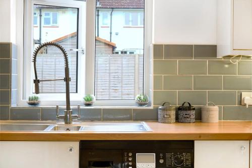 a kitchen counter with a sink and a window at 3-bedroom, sleeps 5 with discounts on long bookings in Loughton