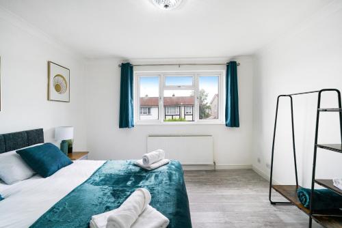 Schlafzimmer mit einem Bett und einem Fenster in der Unterkunft 3-bedroom, sleeps 5 with discounts on long bookings in Loughton