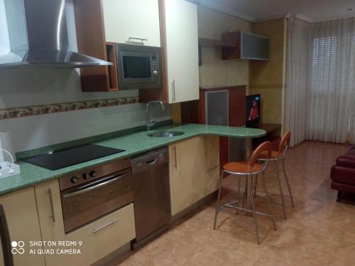 - une cuisine avec un comptoir et des chaises dans la chambre dans l'établissement apartamento Puente, à Suances