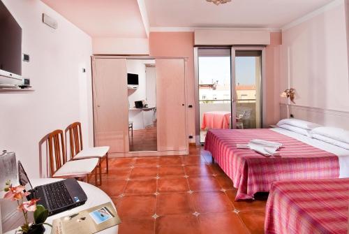 a room with a bed and a laptop on a table at Hotel Le Querce in Senigallia