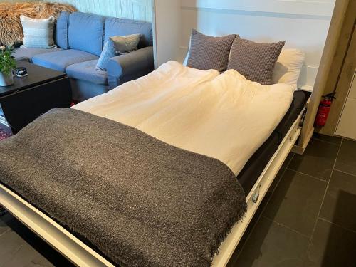 a large bed in a room with a couch at Apartments Bergen with sea view! in Bergen