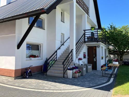 a white house with stairs and a stair case at AGAT Pokoje Gościnne Apartamenty in Pobierowo