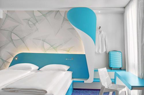 a bedroom with a blue and white bed and a chair at Prize by Radisson, Hamburg St Pauli in Hamburg