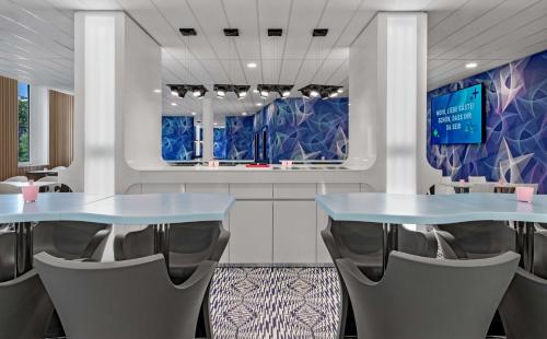 a restaurant with two blue tables and chairs at Prize by Radisson, Hamburg St Pauli in Hamburg