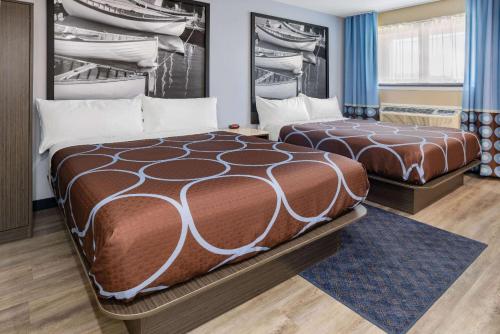 a hotel room with two beds in a room at Super 8 by Wyndham Lindenhurst 