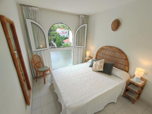 - une chambre avec un grand lit blanc et 2 fenêtres dans l'établissement Apartamentos Fuentesol Altamar, à Alcossebre