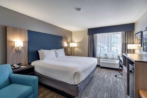 a hotel room with a large bed and a blue wall at SureStay Plus Hotel by Best Western Price in Price