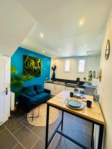 cocina y sala de estar con pared azul en Appartement T2 Florida, en Amiens