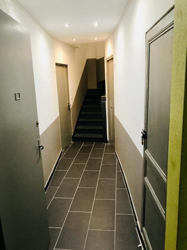 einen Flur mit Türen und Treppen in einem Gebäude in der Unterkunft Appartement T2 Florida in Amiens