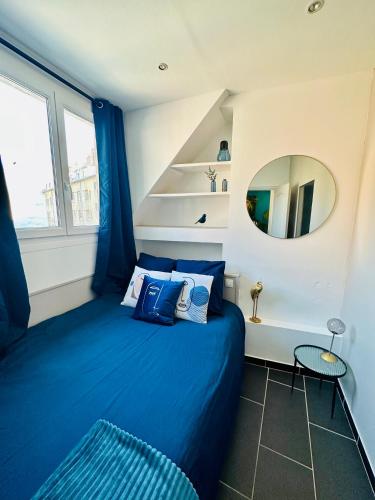 une chambre avec un lit bleu et un miroir dans l'établissement Appartement T2 Florida, à Amiens