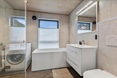 uma casa de banho com um lavatório e uma máquina de lavar roupa em Beachfront Paradise Lofoten em Bøstad