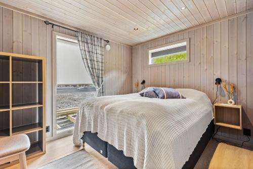 um quarto com uma cama num quarto com uma janela em Beachfront Paradise Lofoten em Bøstad