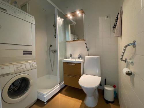 uma casa de banho com um WC, um lavatório e uma máquina de lavar roupa em Casa Marina Naantali em Naantali