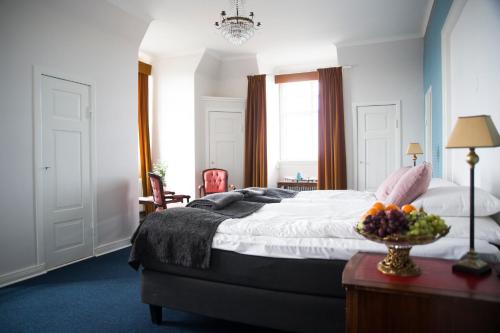 a bedroom with a bed with a bowl of fruit on a table at Eksjö Stadshotell in Eksjö