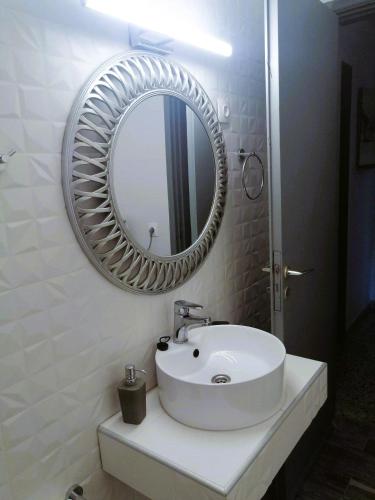 a bathroom with a white sink and a mirror at Vassia's Beach Houses in Benitses