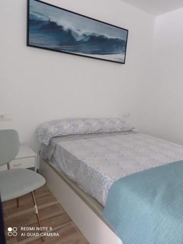 a bedroom with a bed with a picture on the wall at Raquel Apartament in Alicante