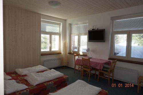 um quarto com duas camas e uma mesa e uma televisão em loft panorama Tre cime Dobbiaco Cortina em Dobbiaco
