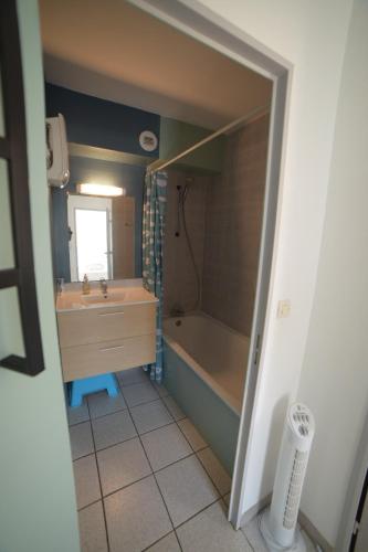 a bathroom with a tub and a sink and a shower at Jolie vue mer T2 tout confort in Cerbère