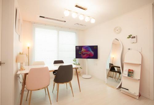 a dining room with a table and chairs and a mirror at Seoul Station Joey House in Seoul