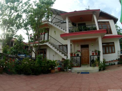 a white house with balconies and flowers in front of it at Bethel homestay Delo in Kalimpong