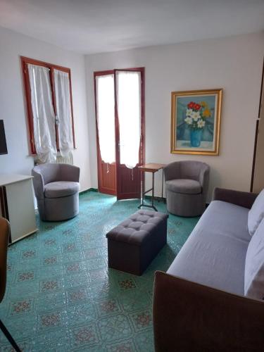 ein Wohnzimmer mit Bett, Sofa und Stühlen in der Unterkunft Venice lagoon suite in Chioggia
