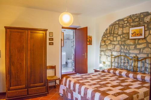 um quarto com uma parede de pedra e uma cama em Villa La Voce Del Vento em Pastena