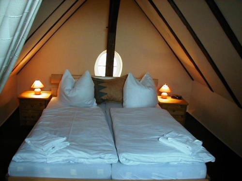 a bedroom with a bed with pillows and a window at Puppenstübchen in Wittenbeck