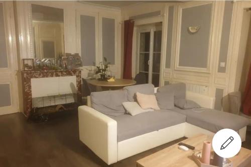 un salon avec un canapé et une table dans l'établissement Appartement idéal en centre ville, à Pont-Audemer