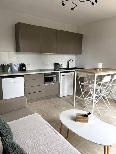 - une cuisine avec un canapé et une table dans une chambre dans l'établissement Cozy flat, quiet retreat w/ queen bed near forest, à Barbizon