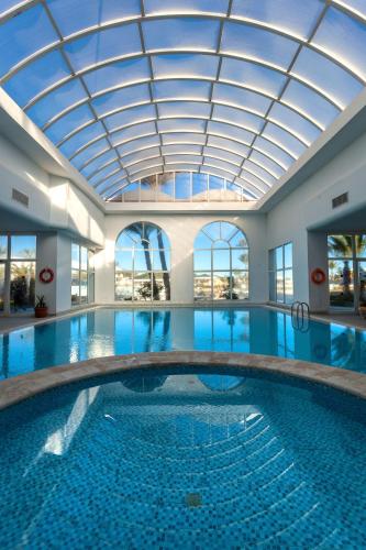 a large swimming pool with a glass ceiling at Djerba Holiday Beach in Midoun