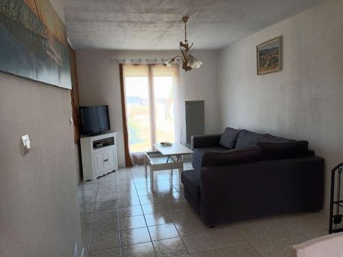 a living room with a couch and a table at Gite maison de campagne in Boissey-le-Châtel