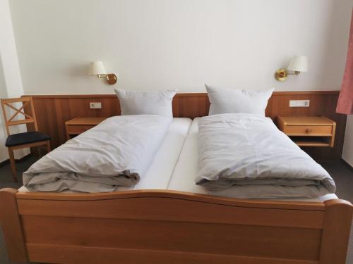 2 camas con sábanas blancas y almohadas en un dormitorio en Kleines Logierhaus 03, en Norderney