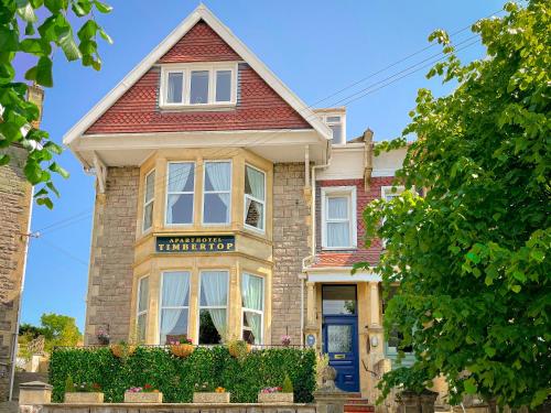 una casa de ladrillo con una puerta azul en Timbertop Suites - Adults Only en Weston-super-Mare