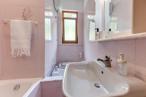 a pink bathroom with a sink and a toilet at Gigli di Firenze in Rufina