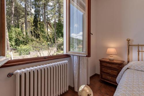 a bedroom with a radiator and a large window at Gigli di Firenze in Rufina