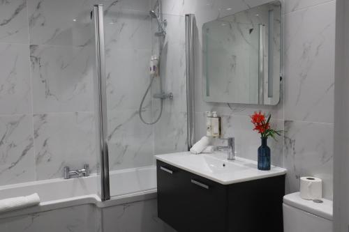a bathroom with a shower and a sink and a mirror at Le Pommier in Castel