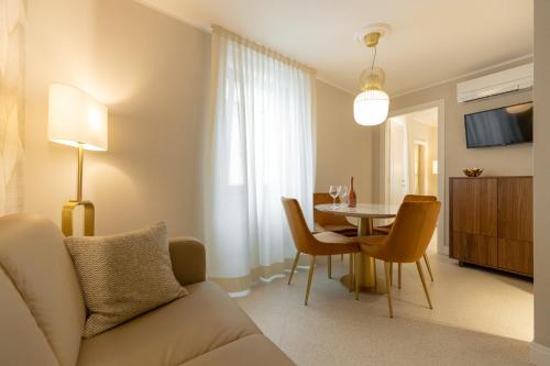 sala de estar con sofá y mesa con sillas en Casa Carmela Apartments, en Bardolino
