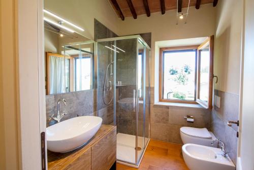 een badkamer met 2 wastafels en een glazen douche bij Casanova di Campriano in Lupompesi