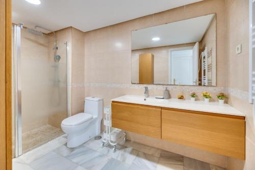 a bathroom with a toilet and a sink and a shower at VB Madeira 1BDR with Rooftop Swimming pool in Benalmádena