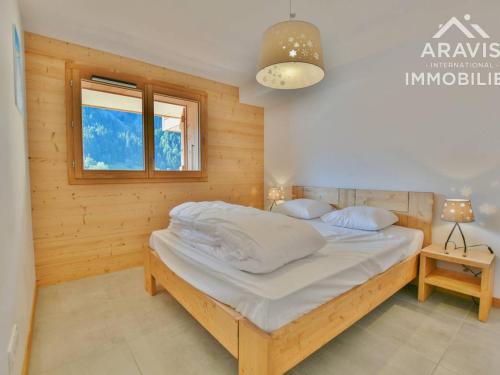 a bedroom with a bed in a wooden room at Appartement Le Grand-Bornand, 3 pièces, 4 personnes - FR-1-391-117 in Le Grand-Bornand