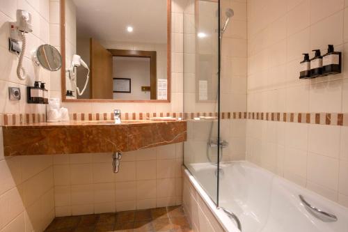 y baño con bañera, lavabo y espejo. en Hotel Màgic La Massana en La Massana