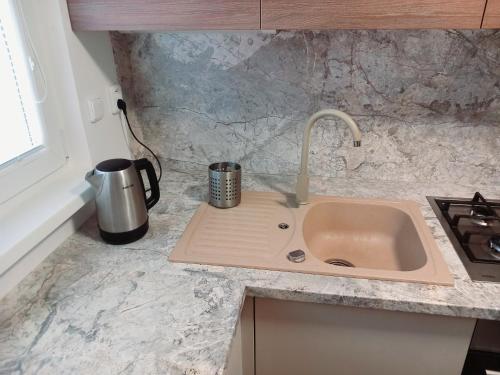 a kitchen counter with a sink and a coffee mug on it at Štýlový apartmán v Šamoríne in Šamorín