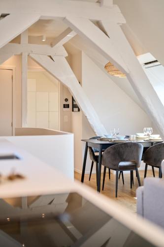 a dining room with a black table and chairs at Place du Grand Sablon in Brussels