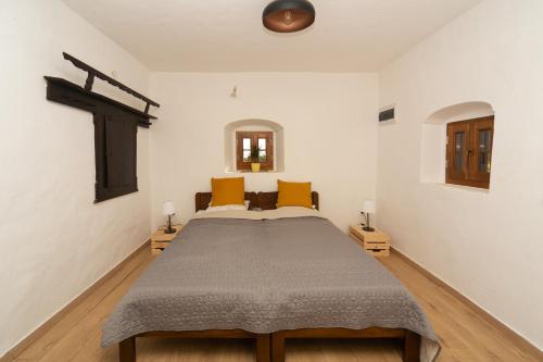 - une chambre avec un lit et une croix sur le mur dans l'établissement Tagyon Birtok Hordó Apartman, à Tagyon