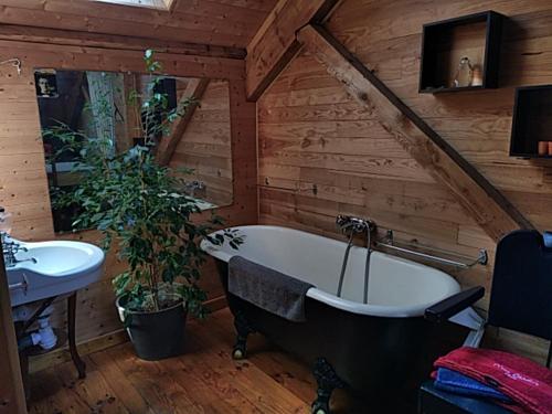 une salle de bain avec une baignoire et un lavabo dans une pièce dans l'établissement Au cœur de saint Agrève -Séjour Chez l'habitant, à Saint-Agrève