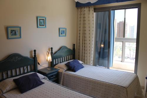 1 dormitorio con 2 camas y ventana en Apartamento Carmenchu Gemelos 20, en Benidorm