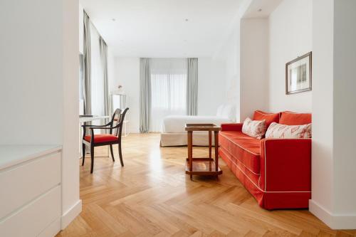 a living room with a red couch and a table at Hotel Morfeo in Milan